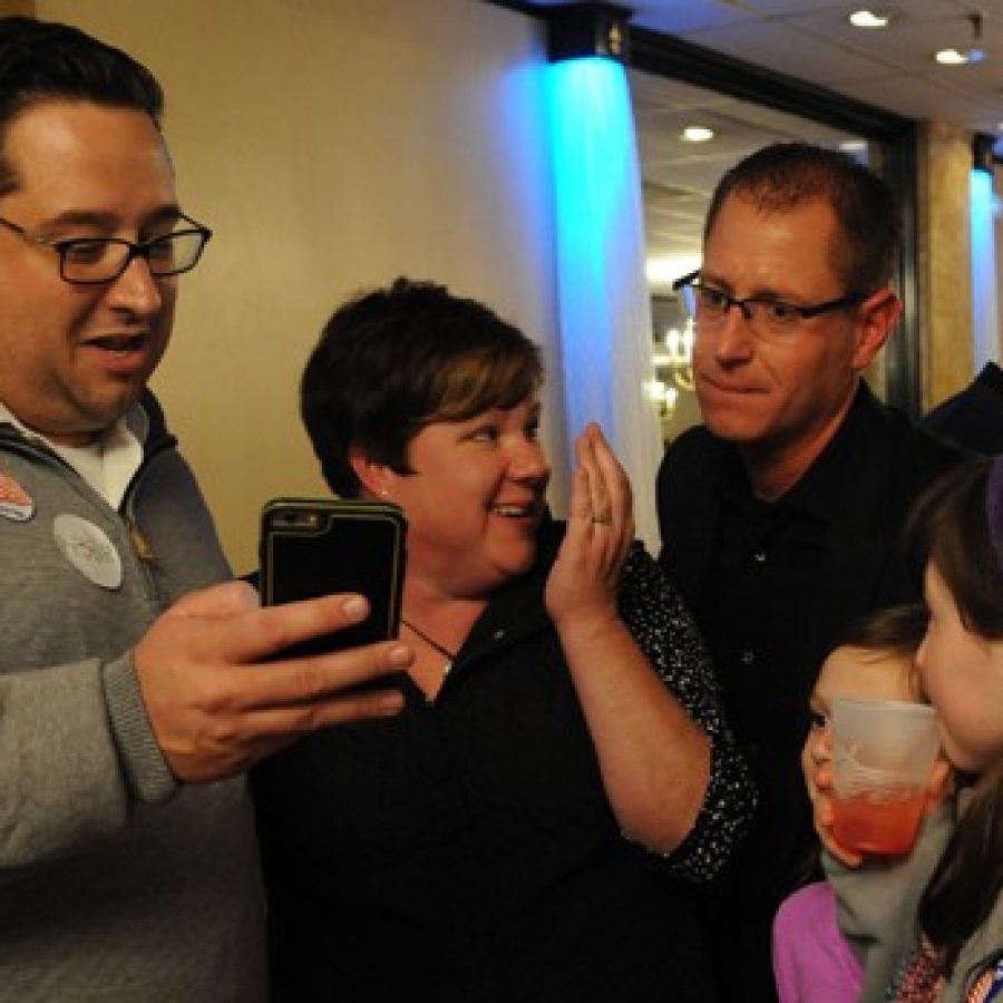 From left, Mark Haefner shows the first wave of Prop R precincts reporting to campaign organizer Kimberly Hanan-West and Assistant Superintendent Jeff Bresler. \Beat my prediction by at least 15 percent,\ a surprised Haefner said. In the background, Dan Fowler shows Superintendent Chris Gaines the results.