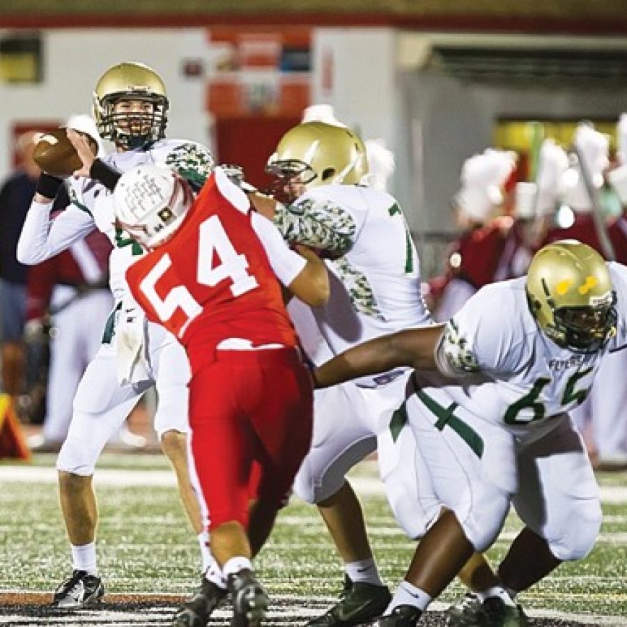 Lindbergh Highs Parker Powell, No. 4, gets off a pass as John Manestar, No. 70, holds off Fox Highs Max Klug, No. 54, in Friday nights game at Fox. The Flyers fell 48-14 to the Warriors. Megan LeFaivre-Zimmerman photo