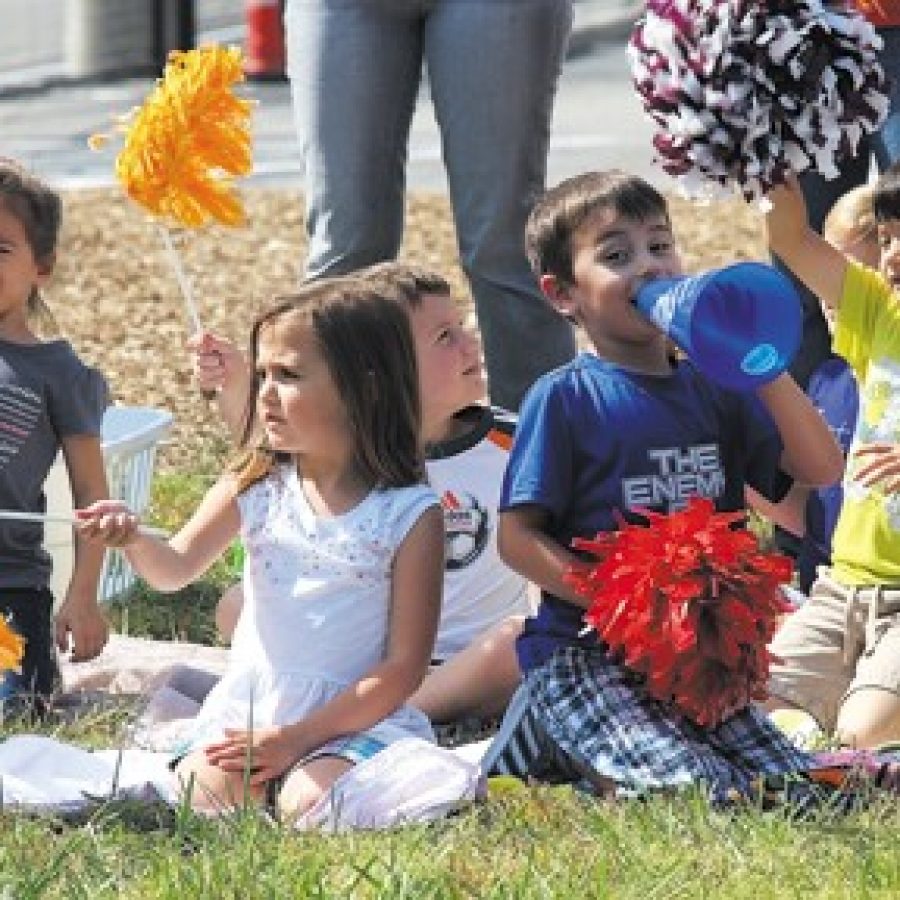 Students in kindergarten through fourth grade line the field to cheer on their older classmates during this years Character at Play game, while teachers from all grade levels took turns at bat.