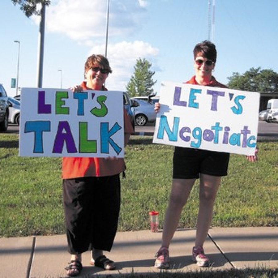 Sperreng Middle School teachers Becky Hunt, left, and Janice Harke were among the Lindbergh Schools teachers lining South Lindbergh Boulevard before last week's Board of Education meeting. Teachers representing the Lindbergh National Education Association, or LNEA, have accused district officials and board members of not bargaining in good faith and want negotiations to be reopened.Photo by Mike Anthony