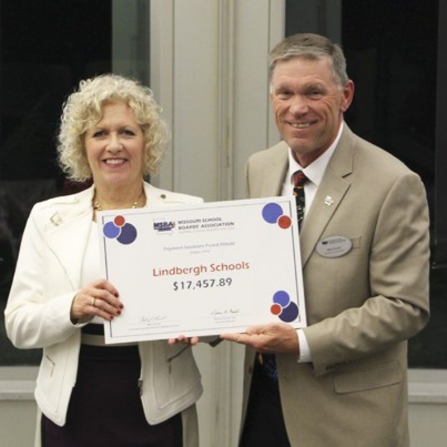 Mike Parnell of the Missouri School Boards Association presents Lindbergh Board of Education President Kathy Kienstra with a rebate check totaling \$17,457.89 for fiscal 2016.