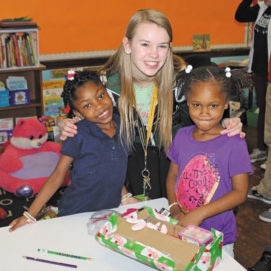 Mehlville High National Honor Society members made their annual trek last week to Clay Elementary School in north St. Louis to continue a holiday tradition. The Shoebox Project provides gifts to nearly 200 Clay students as a way to bring together two distant and different communities. Mehlville High student Logan Merz is pictured with two Clay students.