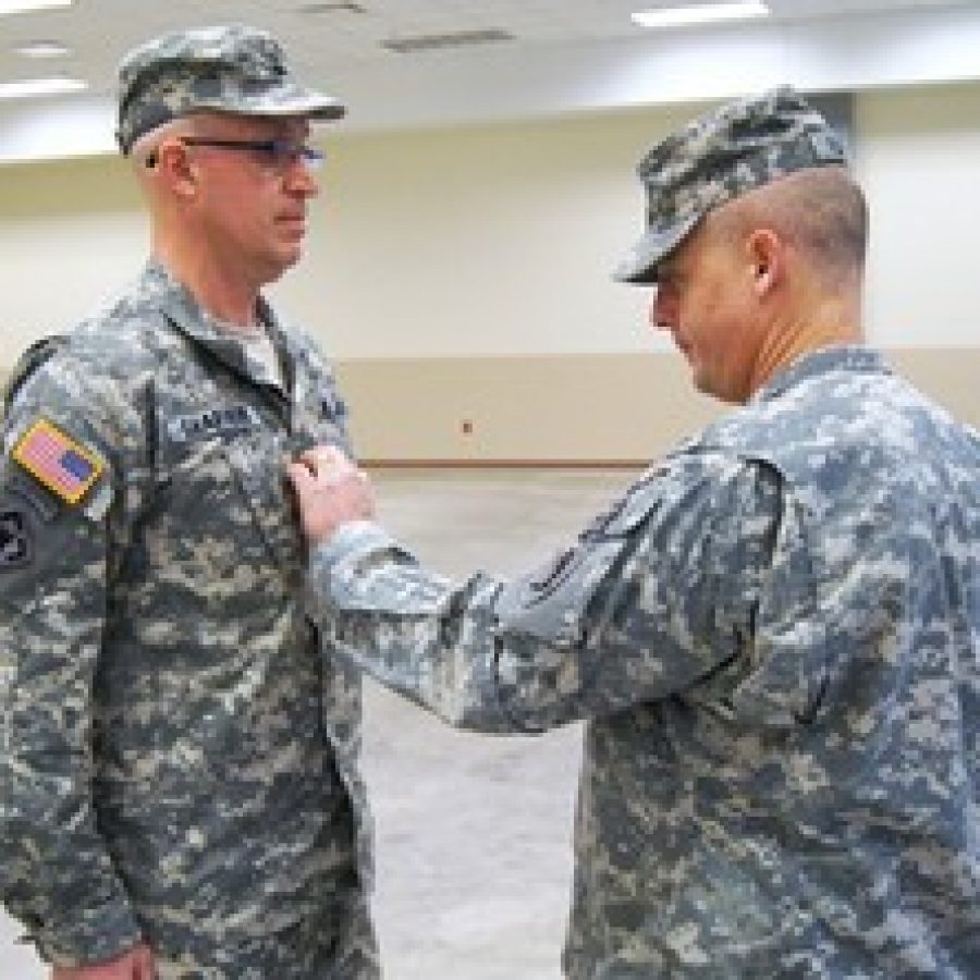 Col. James G. Allison, right, commander of the Missouri National Guards 70th Troop Command, affixes the rank of lieutenant colonel to the uniform of Lance Shaffer, of Oakville, during Shaffers promotion ceremony at historic Jefferson Barracks 