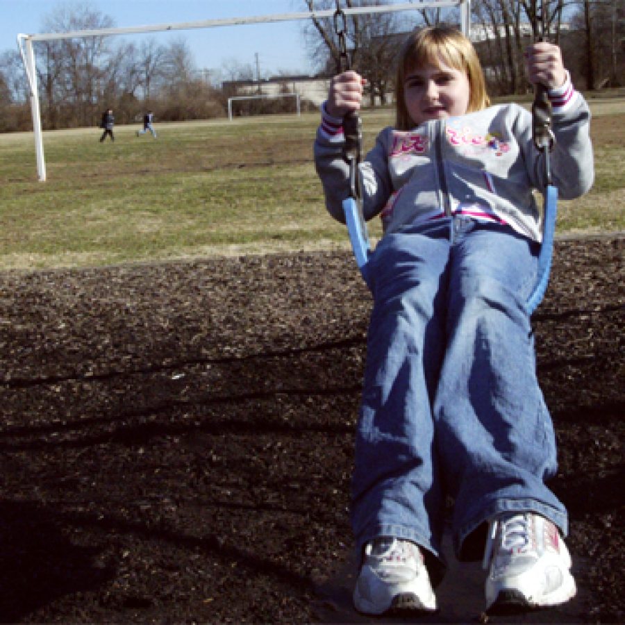 Elizabeth Alloway enjoys the swing during recess Friday afternoon at Crest-wood Elementary School. Lindbergh School District officials oppose a proposal to construct a 30-foot-tall office/warehouse building that would back to the schools playground area.