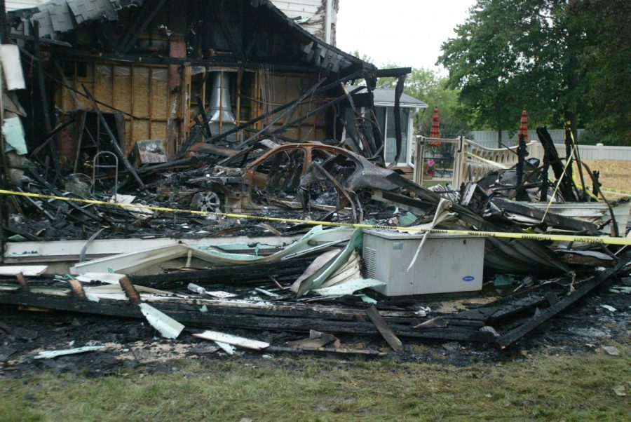 The remnants of a garage and a car inside it destroyed in a fire Monday, seen the day after the fire.