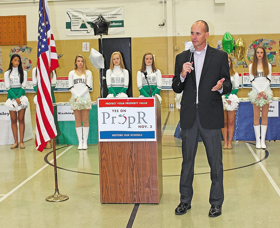 Superintendent Chris Gaines asks supporters at a 2015 rally for Prop R to help him get out the vote so that he can hire reading coaches and keep experienced teachers in the district. Behind him are the Mehlville High School Pantherettes and the Oakville High School Golden Girls.