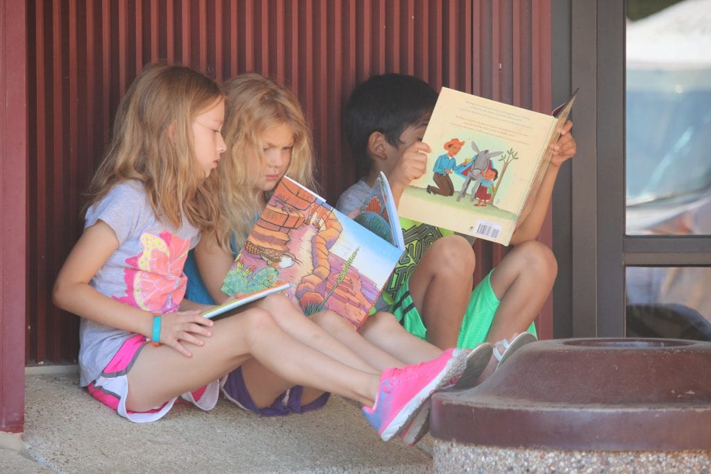 Incoming second-grader Aubrey Nicholson, first-grader Makenna Kessler and second-grader Moussa Moftin read their brand new books-together at the Bring Me a Book event in 2018.