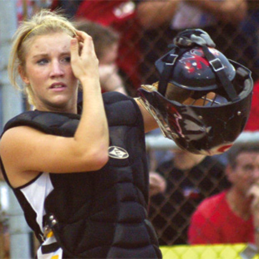 Oakville catcher Nicole Jost, left, a junior, prepares to get behind the plate during the semifinal round of the state softball championship in Columbia.