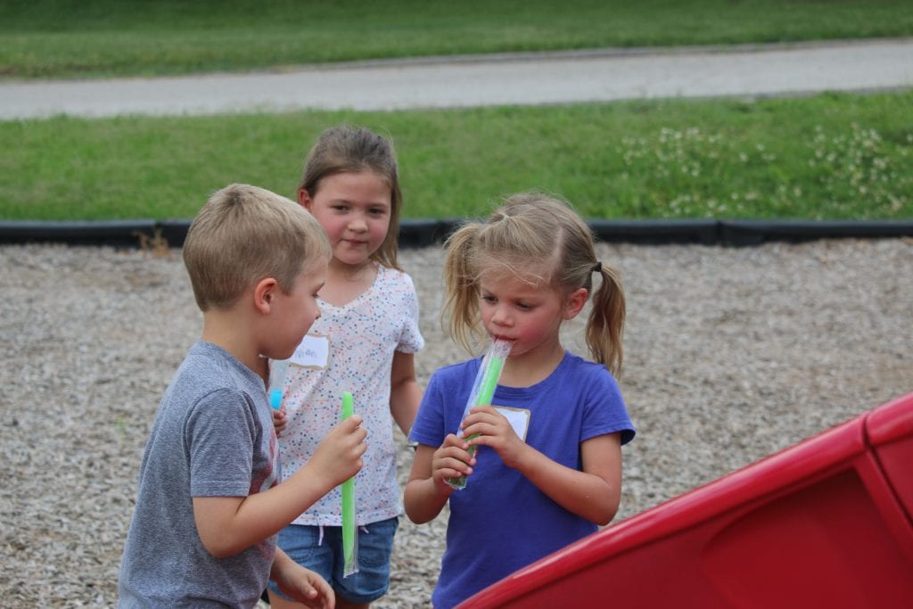 Incoming Kennerly kindergarteners Andrew and Hailey enjoy the Popsicles that Principal Todd Morgan handed out.