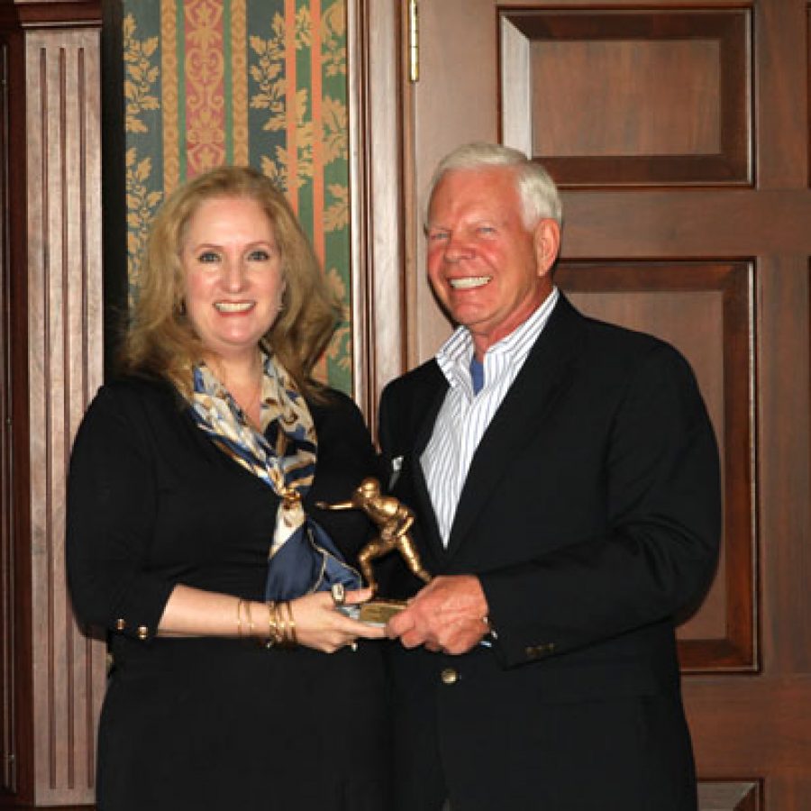 Rams owner Lucia Rodriguez presents Oakville resident Lee Burkemper with his award as a finalist for the Georgia Frontiere Community Quarterback Award.