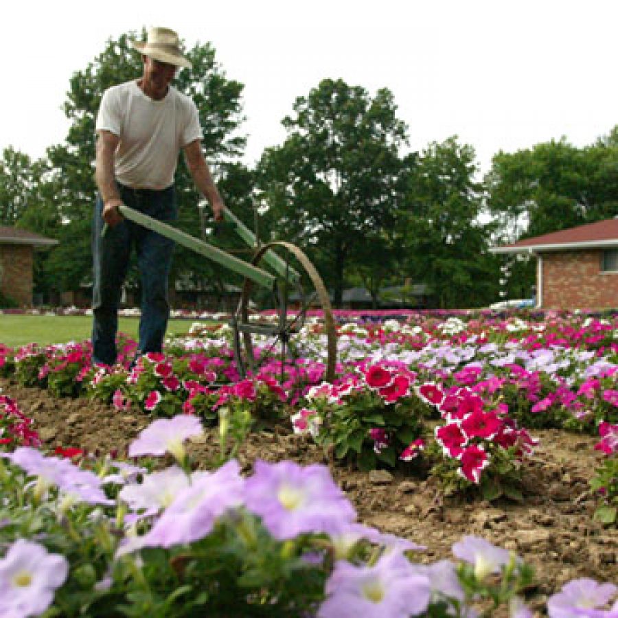 Robert Lightfoot uses a hand cultivator in his garden at 12045 Theiss Road