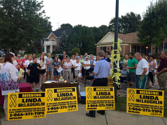 Linda McLaughlins pastor, Joel Christianson, center in blue, leads attendees at a candlelight vigil last fall in a prayer for her safe return. Photo by Gloria Lloyd.