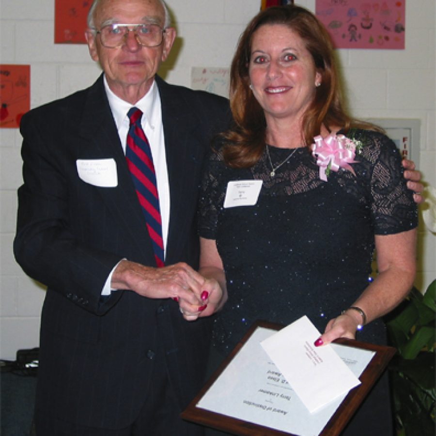 Terry Linkemer, right, receives the Robert D. Elsea Scholarship Award from Elsea, who served as executive director of the Cooperating School Districts for 21 years.