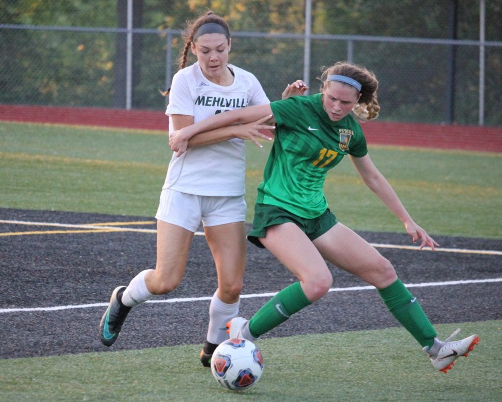 Lindbergh junior Maura Haegele, right, defends the ball from Mehlville sophomore Kailee Wisber in the district championship game May 15. Photo by Erin Achenbach 
