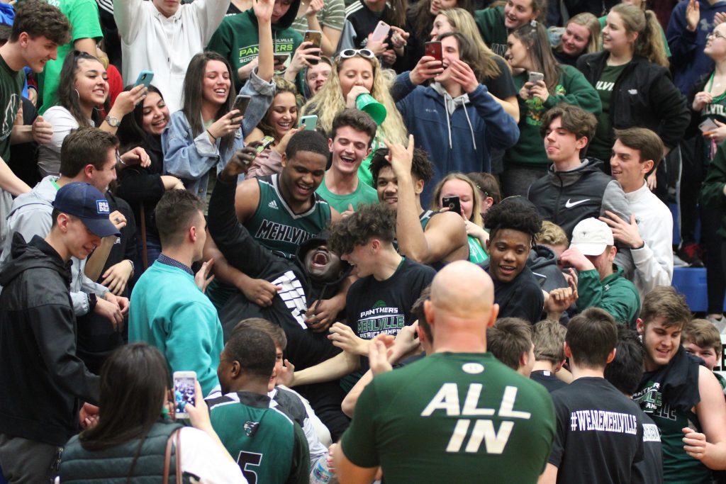 It+was+pandemonium+after+the+Mehlville+High+School+Panthers+boys+basketball+team+won+the+sectional+championship+versus+Jackson+in+Hillsboro+to+make+the+state%E2%80%99s+Elite+Eight+in+March+2019+.+After+wading+into+the+crowd+to+celebrate+their+win%2C+Mehlville%E2%80%99s+King+Waller+and+Davion+Bradford+take+selfies+with+fans.+The+team+went+on+to+lose+in+the+state+quarterfinals+that+year+against+CBC.++