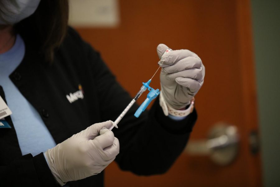 A nurse at Mercy Hospital South prepares the first dose of Pfizer/BioNTech's COVID-19 vaccine for Mercy's Chief Medical officer Aamina Akhtar Monday, Dec. 14. Mercy South planned to vaccinate 20 workers Dec. 14 and another 20 staffers Dec. 15.