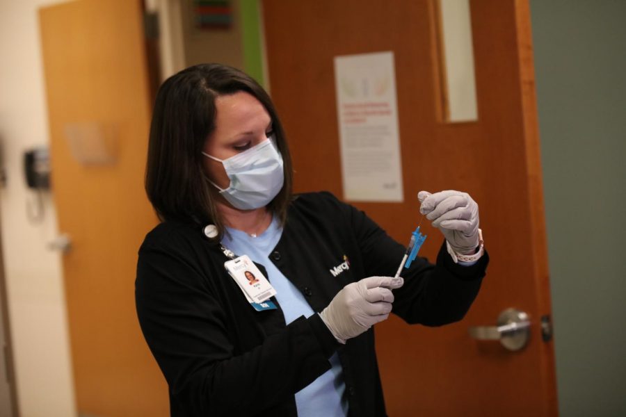 A nurse at Mercy Hospital South prepares the first dose of Pfizer/BioNTech's COVID-19 vaccine for Mercy's Chief Medical officer Aamina Akhtar Monday, Dec. 14, 2020. Mercy South planned to vaccinate 20 nurses on Dec. 14 and another 20 nurses on Dec. 15. 