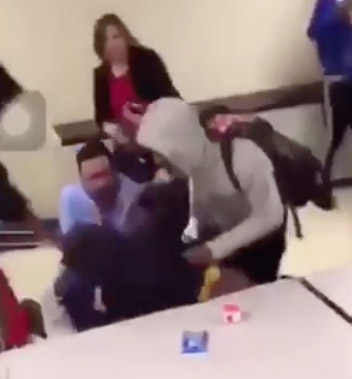 This screenshot taken from a blurry video a student posted to Snapchat Monday shows Oakville High Principal Jan Kellerman, top, intervening in a fight along with who appears to be Assistant Principal Casey Olearnick, in a blue shirt at the bottom. Assistant Principal Brian Brennan is on the ground in the dark blue shirt.