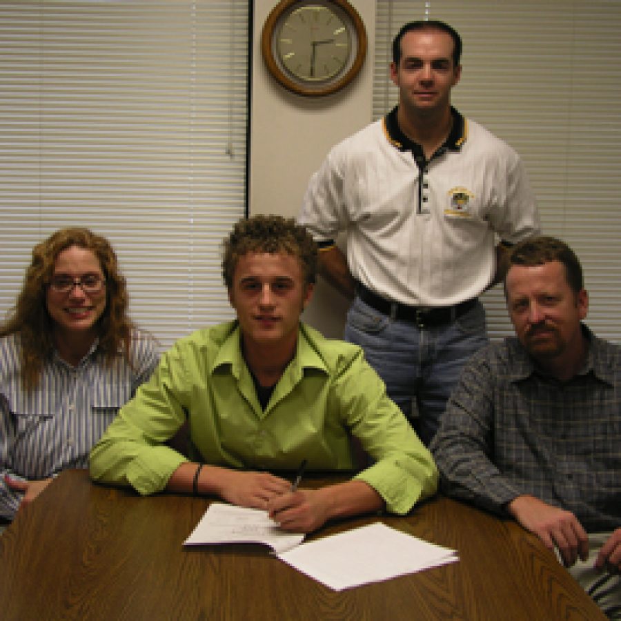 Oakville Senior High School baseball player Andy Marks signs his letter of intent with the University of Kansas. Shown with Marks are his parents, Nanette and Kevin Marks, and baseball coach Rich Sturm, standing.