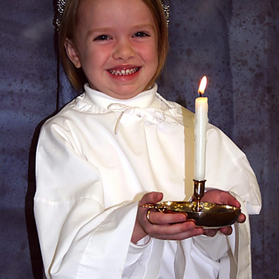 Sprite Amelia Dowell of Peace Lutheran Church holds the Christ Candle for the Boars Head Christmas Festival.