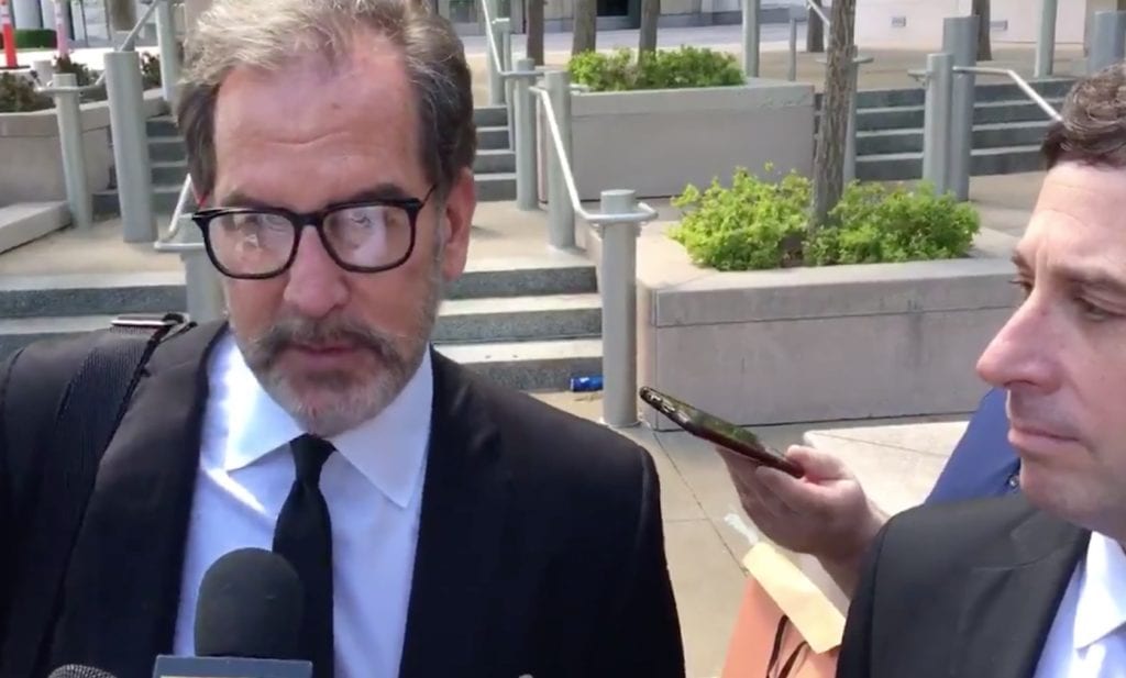 In this still taken from a video by Jason Rosenbaum of St. Louis Public Radio, former County Executive Steve Stenger, right, listens as his attorney Scott Rosenblum makes remarks to reporters after Stenger's arraignment April 29, 2019, on federal corruption charges. 