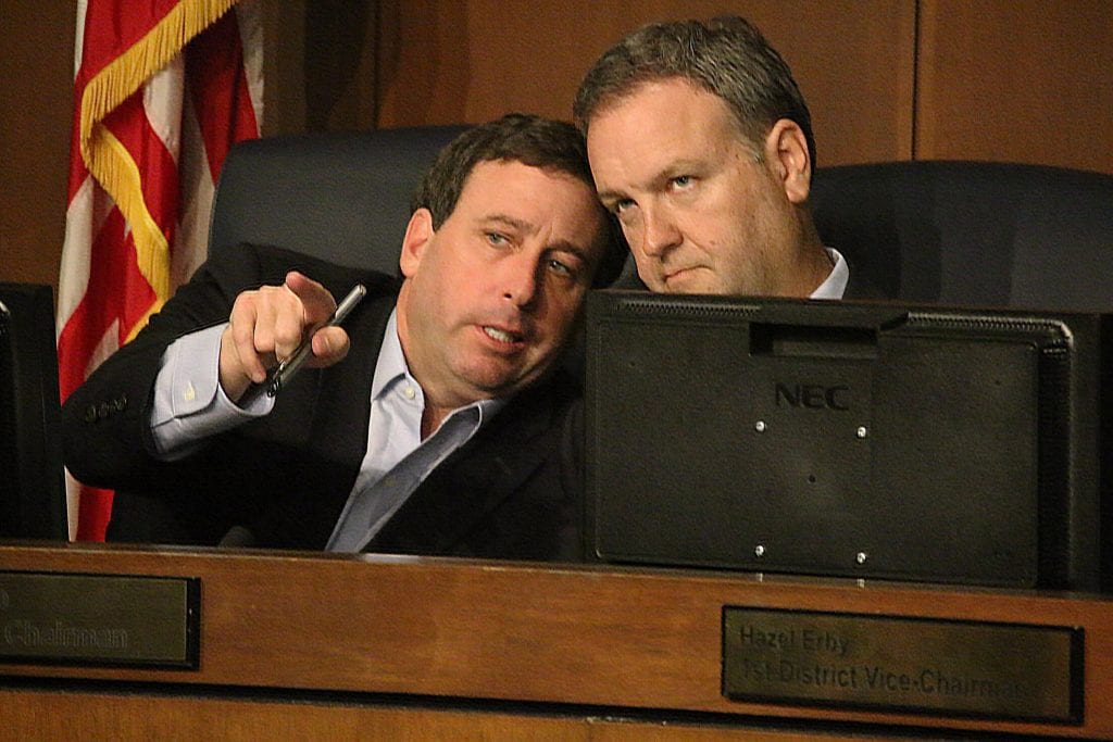 County Executive Steve Stenger, left, talks to council Chairman Sam Page, D-Creve Coeur, at the Aug. 1 council meeting. Photo by Jessica Belle Kramer.