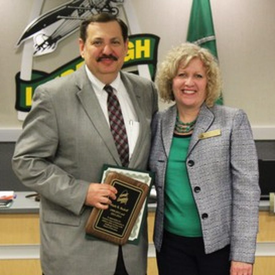 Departing Lindbergh Schools Board of Education member Mark Rudoff is presented with a resolution in honor of his service by board President Kathleen Kienstra. 