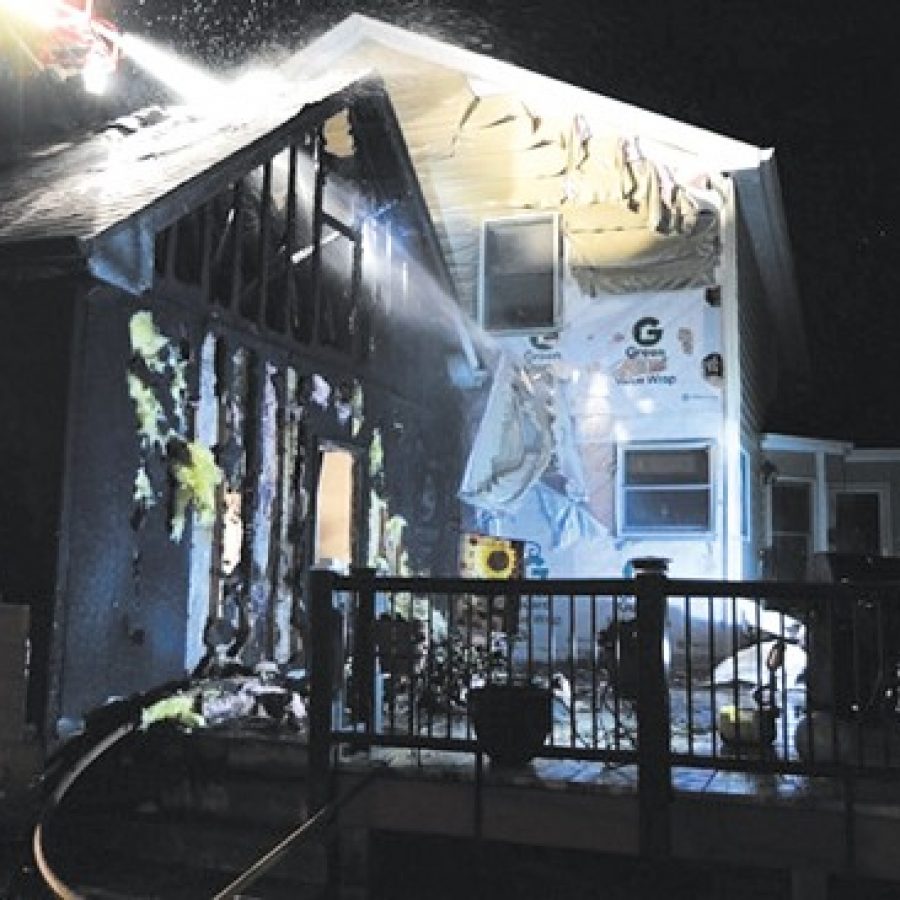 Mehlville Fire Protection District firefighters, assisted by members of the Lemay Fire Protection District, douse this deck fire at an Oakville residence.