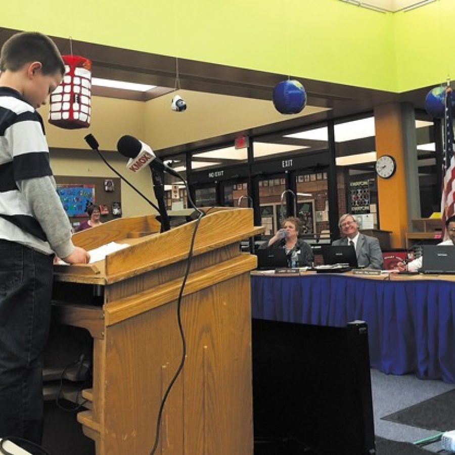 The Mehlville Board of Education may have heard from its youngest public speaker ever at its March 25 meeting, Point Elementary second-grader Dylan Lohrke. Dylan, who is standing on a chair so he could reach the podium, outlined how budget cuts could affect him. Also pictured, from left, are board members Jean Pretto, Larry Felton and Venki Palamand. Dylan also spoke at last weeks meeting at Andres Banquet Center that drew 300 people.