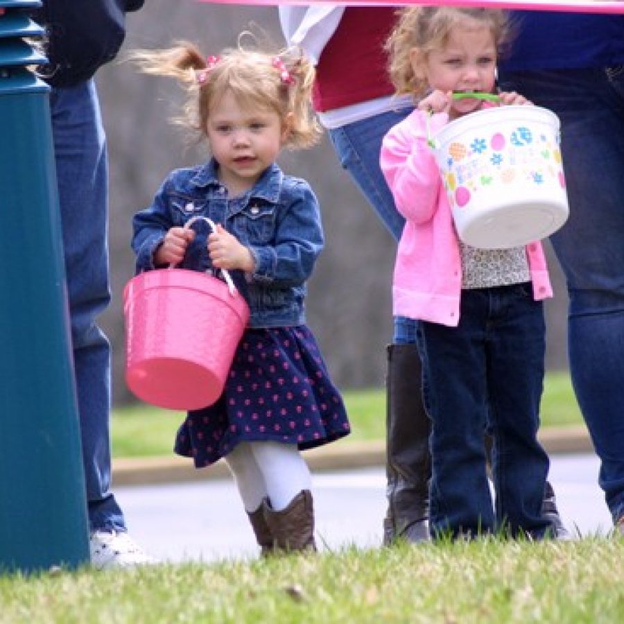 Three-year-olds Makenzie Hoffman, left, and Natalie Curtis are eager with anticipation as they cant wait to begin collecting eggs at the Easter Eggstravaganza Sunday afternoon at Delmar Gardens South and Garden Villas South.