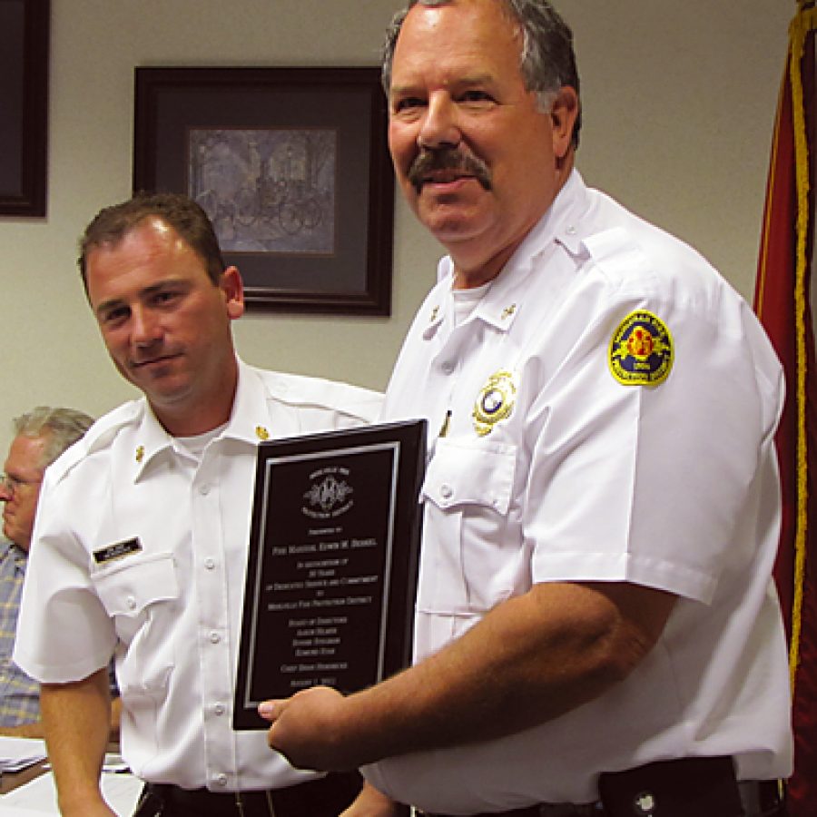 Mehlville Fire Marshal Ed Berkel, right, receives a plaque honoring his 30 years of service to the fire district from interim Chief Brian Hendricks.