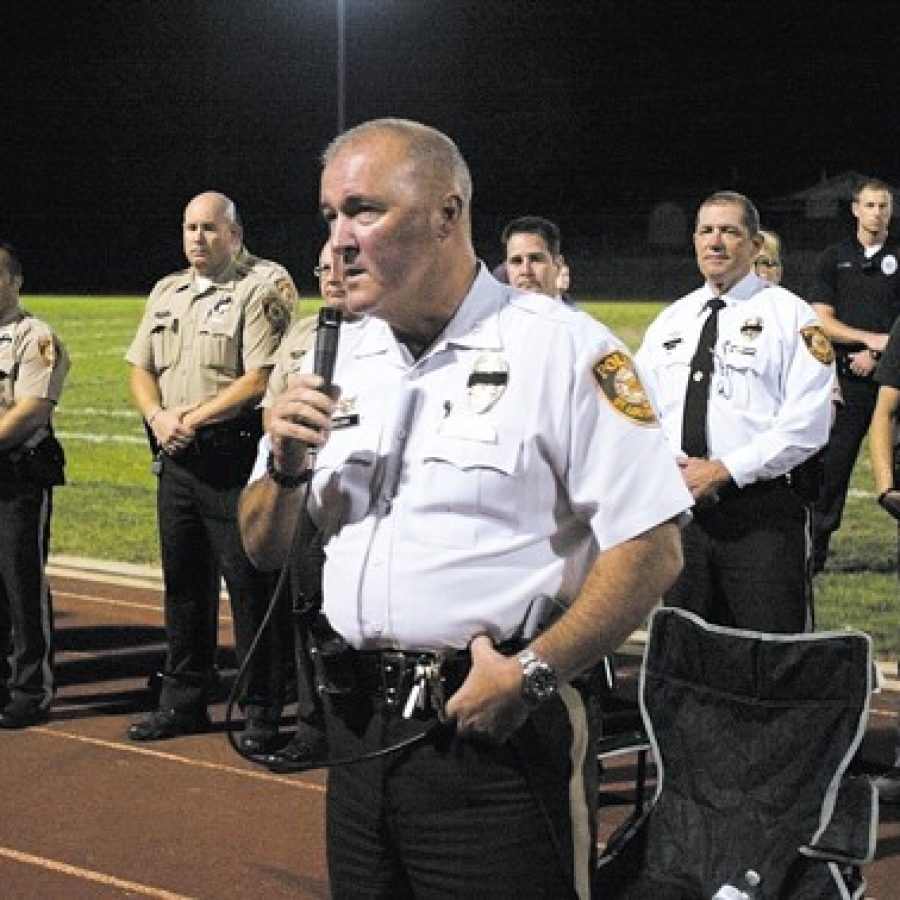 St. Louis County Police Chief Jon Belmar, foreground, thanks the roughly 1,000 people who attended a candlelight vigil Oct. 6 to honor Officer Blake Snyder, who was shot and killed earlier that day as he responded to a call in Green Park. Behind Belmar, first responders line up at the Affton High School football field to show their support for Officer Snyder.