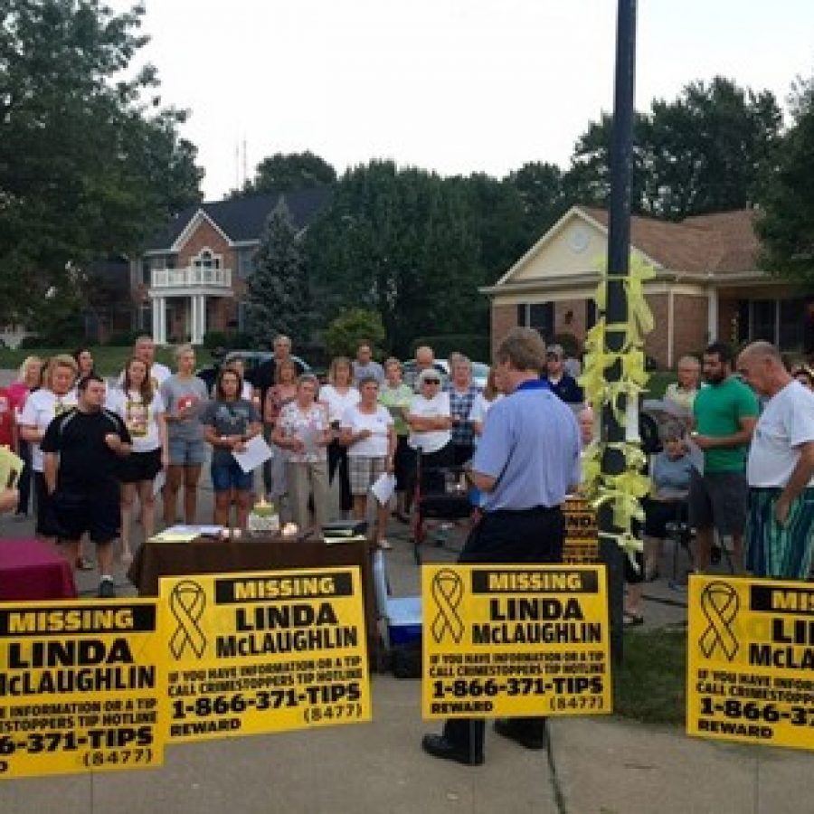 Linda McLaughlins pastor, Joel Christianson, center in blue, leads attendees at a candlelight vigil last fall in a prayer for her safe return. Photo by Gloria Lloyd. 