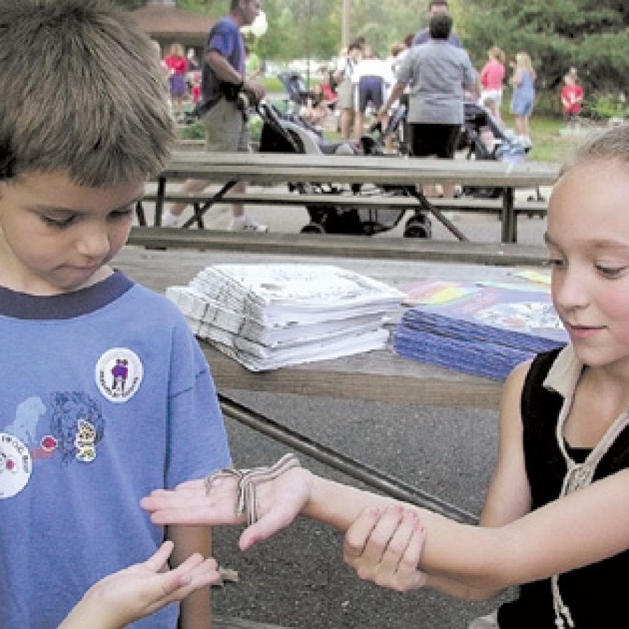 Four-year-old Tommy Shotton, left, keeps a close eye on a rosy boa held by Sierra Sagitto during the Creeping Critters event.