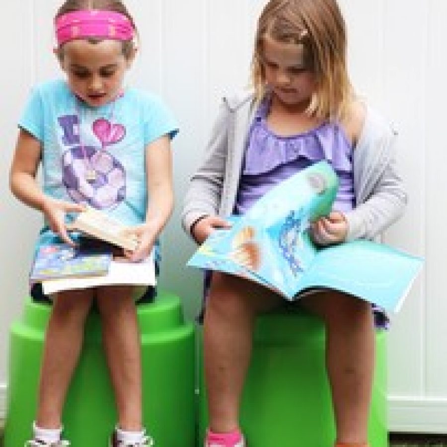 Long Elementary School first-graders Lauren Karberg, left, and Lilly Carver read together in the schools outdoor learning space during the schools Literacy Festival. 