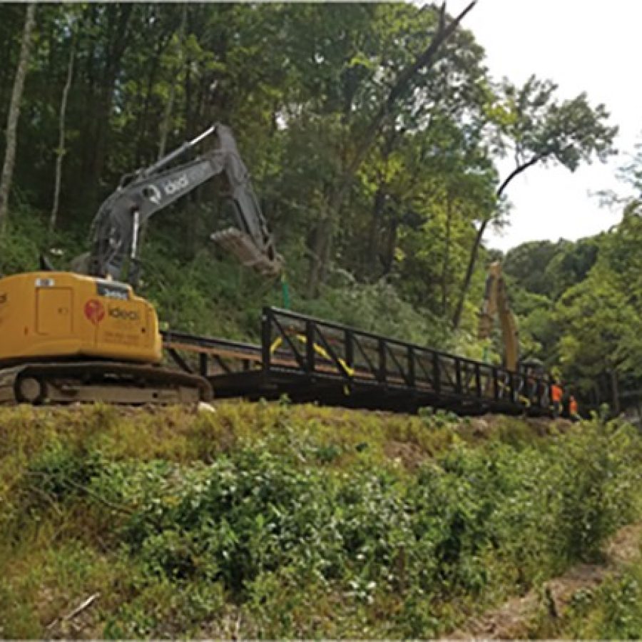 Mississippi Greenway construction crews install the first of two greenway bridges in Cliff Cave Park.