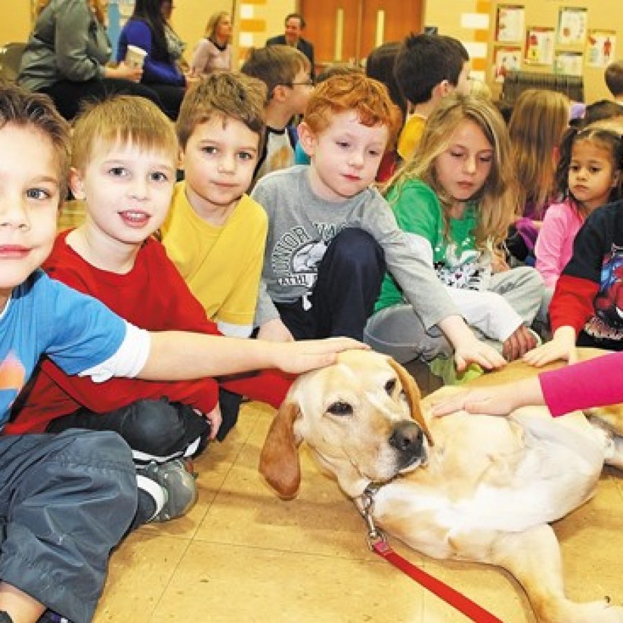 A bona fide movie star recently visited students at Rogers Elementary School. Marshall, a rescue dog with three legs, will have his life portrayed in a movie later this year. Cindi Willenbrock, Marshalls owner, read to students from Marshall the Miracle Dog, a book she authored about Marshalls life. Above, Rogers students are pictured with Marshall.
