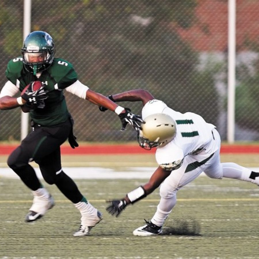 Mehlville Highs Jabari Shelton, left, eludes Lindberghs Charlie Brown in Friday nights football game. Shelton scored six touchdowns against the Flyers.