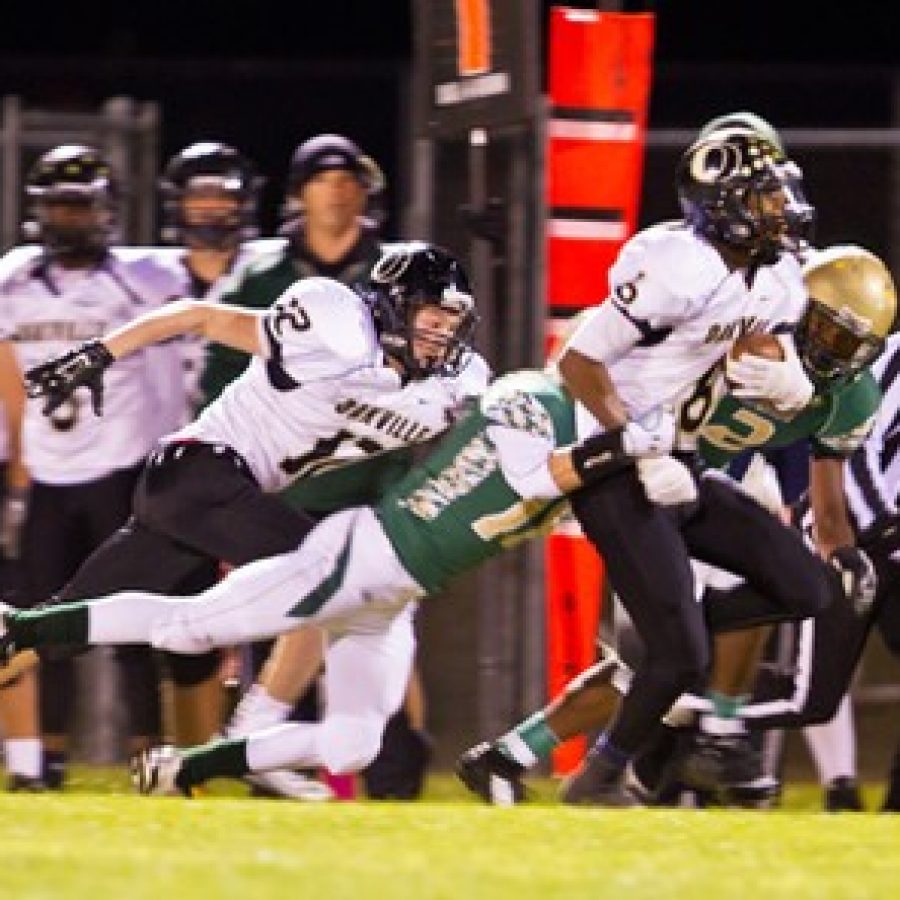 Lindbergh Highs Jaron Heller, No. 18, and Malik Johnson, No. 2, take down Oakville HIghs Antwan Banks, No. 6, in Friday nights game. The Flyers prevailed 10-7. Megan LeFaivre-Zimmerman photo