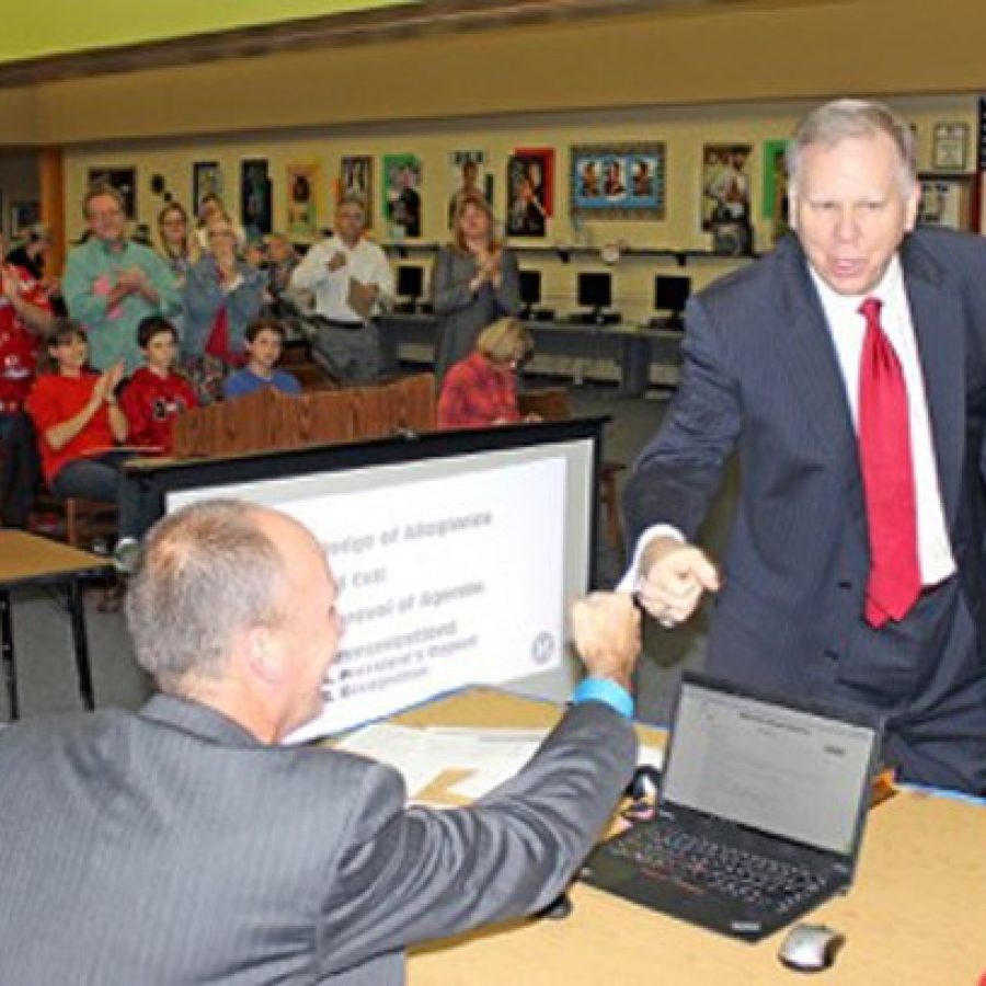 Dan Fowler, right, fist bumps Superintendent Chris Gaines after the naming vote.