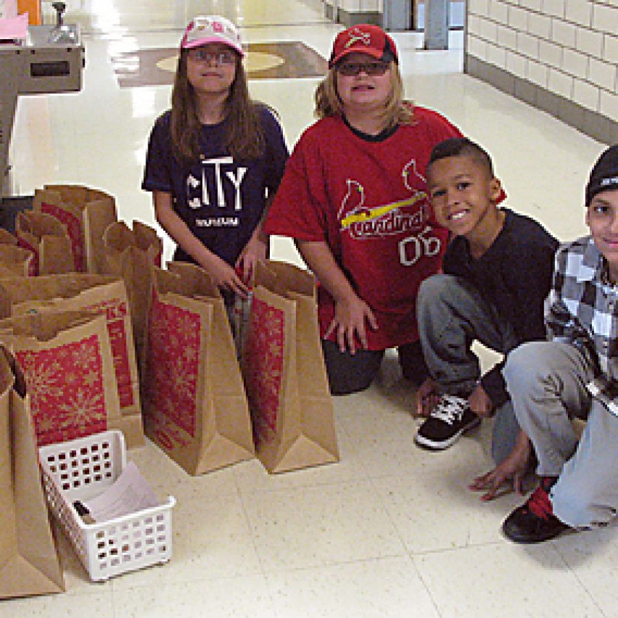 Bierbaum Elementary third graders, from left, Kristin Hurston, Kayla Rieke, Jordan Bergfeld and Trevon Earl assemble healthy recipe packs for Feed My People. Based on the schools efforts to eliminate hunger and help the community, Bierbaum was named a Feinstein School of Excellence by the Feinstein Foundation.