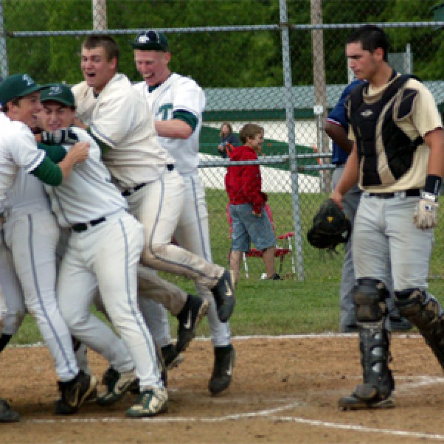 One wonders what senior catcher Ryan Huck is thinking as he paces back to the Oakville bench at the close of last Tuursdays 2-1 loss at DeSoto high school. Celebrating Dragons offer a stark contrast to Hucks visage.