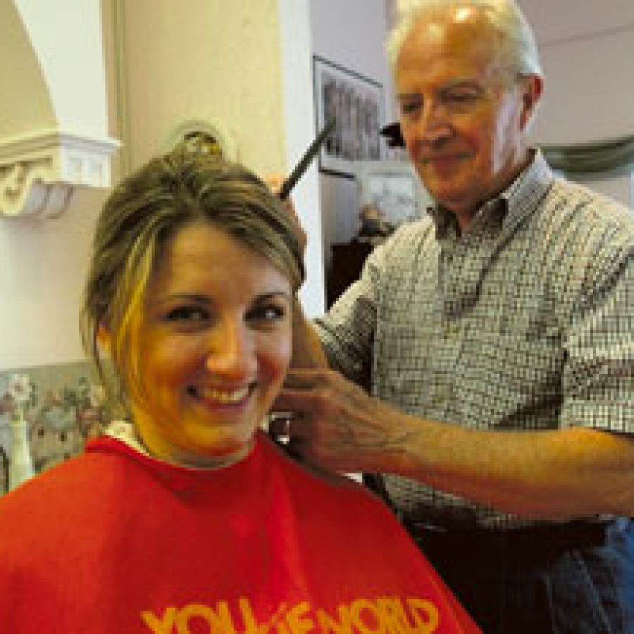 Being sheared by a pro, Angie Schoenecker updates her hairstyle with the help of Ken Henley, former Kens Kontinental owner of 31 years. Henley continues at the Oakville barbershop, now known as Gails Place, despite new ownership. 