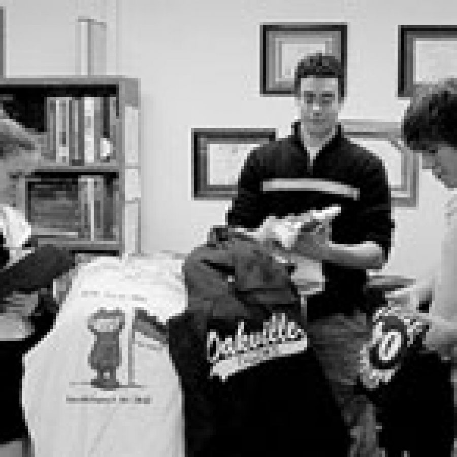 Oakville students, from left, Nikki Hobbs, Jordan Mroz and Nate Hoffman, take inventory of a recent shipment for Tiger Ts and prepare the German Club order for delivery. 