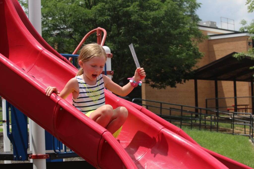 An incoming Kennerly kindergartener slides at Popsicles with the Principal in 2018 on the schools playground.  Photo by Jessica Belle Kramer.