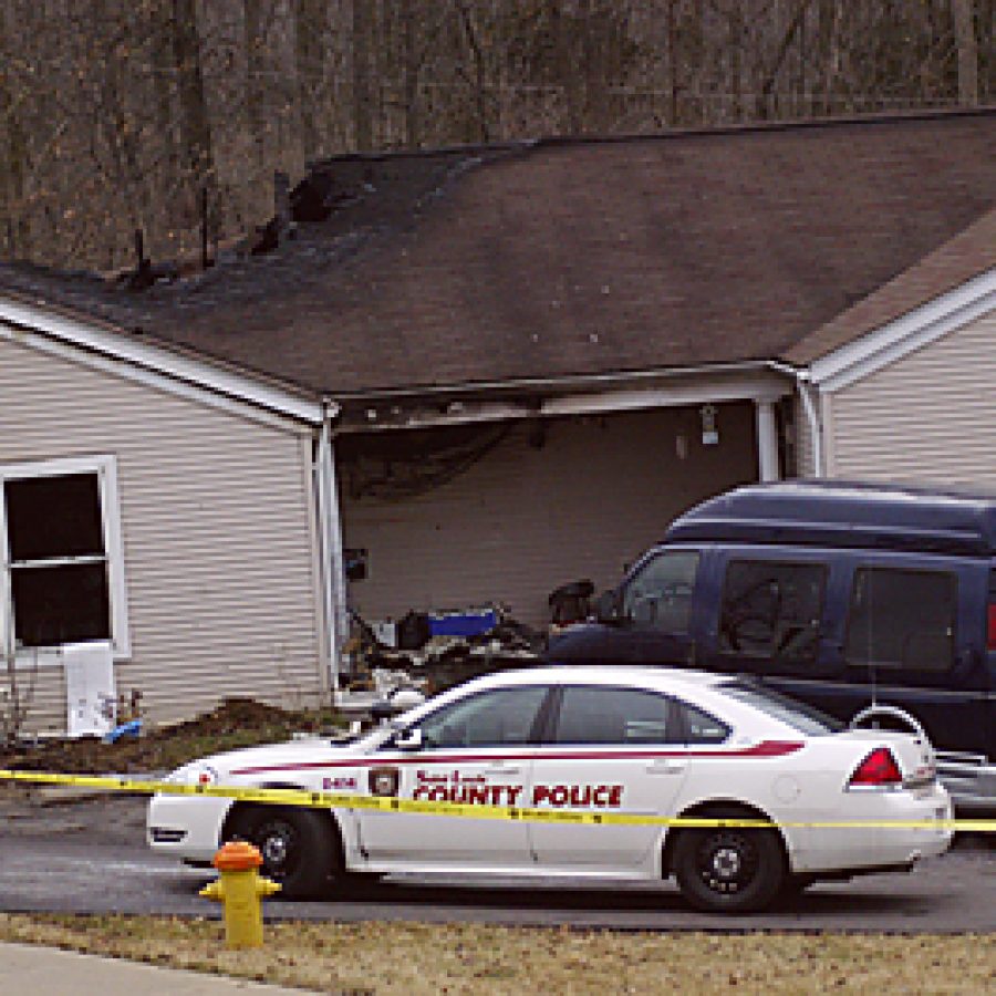 Police tape surrounds the charred Kinswood Lane duplex where firefighters Wednesday morning discovered the body of Mark J. Woods, 40. Bill Milligan photo