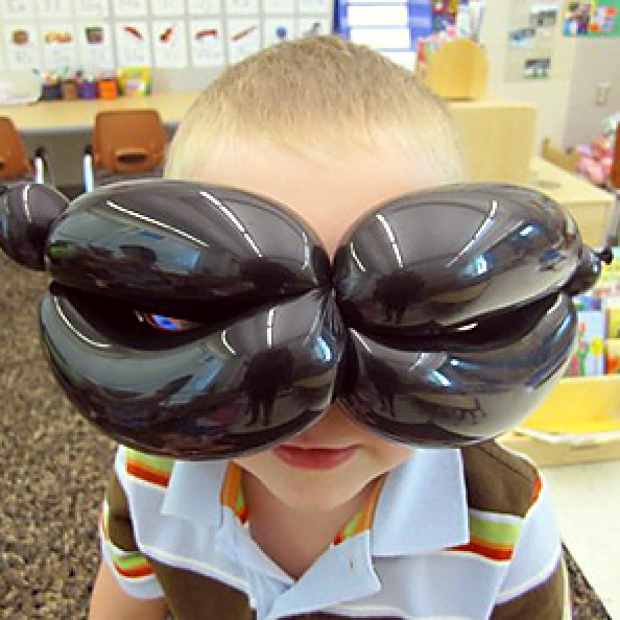 Pre-kindergarten student Zachary Ringhofer tries on a balloon mask at Lindbergh Early Childhood Education during a presentation from special visitor Jason Vaughn. \Mr. Jason\ created balloon characters and balloon costumes while he told stories to the children. Students were amazed at how quickly he could twist and turn the balloons into crowns, brooms, windows and various animals. Zachary and the rest of his classmates in the Piglet room enjoyed participating in the stories as well.