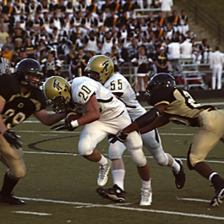 After catching a 25-yard pass from Lindbergh quarterback Peter Simpson, Grant Krueger, No. 20, is about to break free of these Oakville defenders Friday night and score the first touchdown of the season for the Flyers. The touchdown came with 5:03 left on the clock in the first quarter. The Flyers went on to shut out Oakville 42-0 in the season opener for both teams.