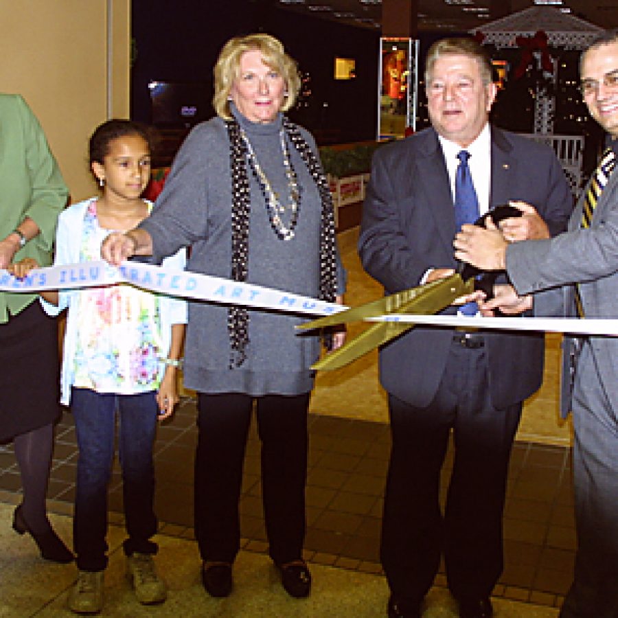 St. Louis native and internationally known artist Mary Engelbreit, center, joined Crestwood Mayor Roy Robinson and Childrens Illustrated Art Museum Director Jimmy Johnston, right, last week in cutting a ribbon to mark the grand opening of the Mary Engelbreit Christmas Experience. Also pictured is AmerenUE representative Karen Foss, left, and Mikayla Delano. Ameren is a corporate sponsor of the exhibit. Bill Milligan photo
