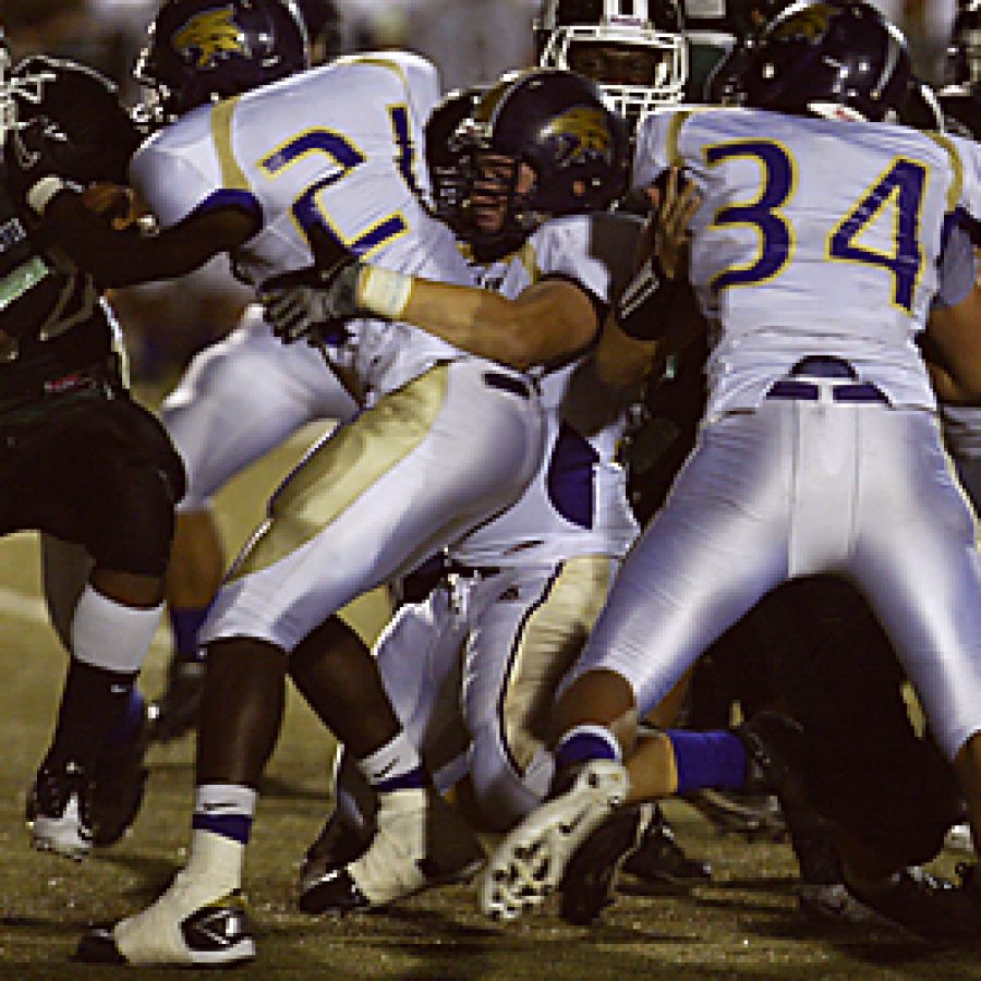 Mehlvilles Mike Sulya, left, is on his way to a short gain during first-half play Friday night against Eureka. Waiting for him are a host of Eureka players preparing for the tackle. Eureka won the contest 57-33, handing Mehlville its first loss of the season. Bill Milligan photo